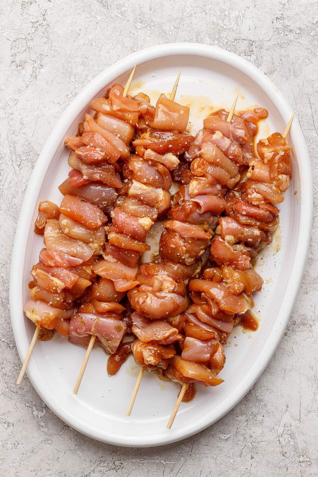 Thai chicken skewers on a plate before going on the grill.
