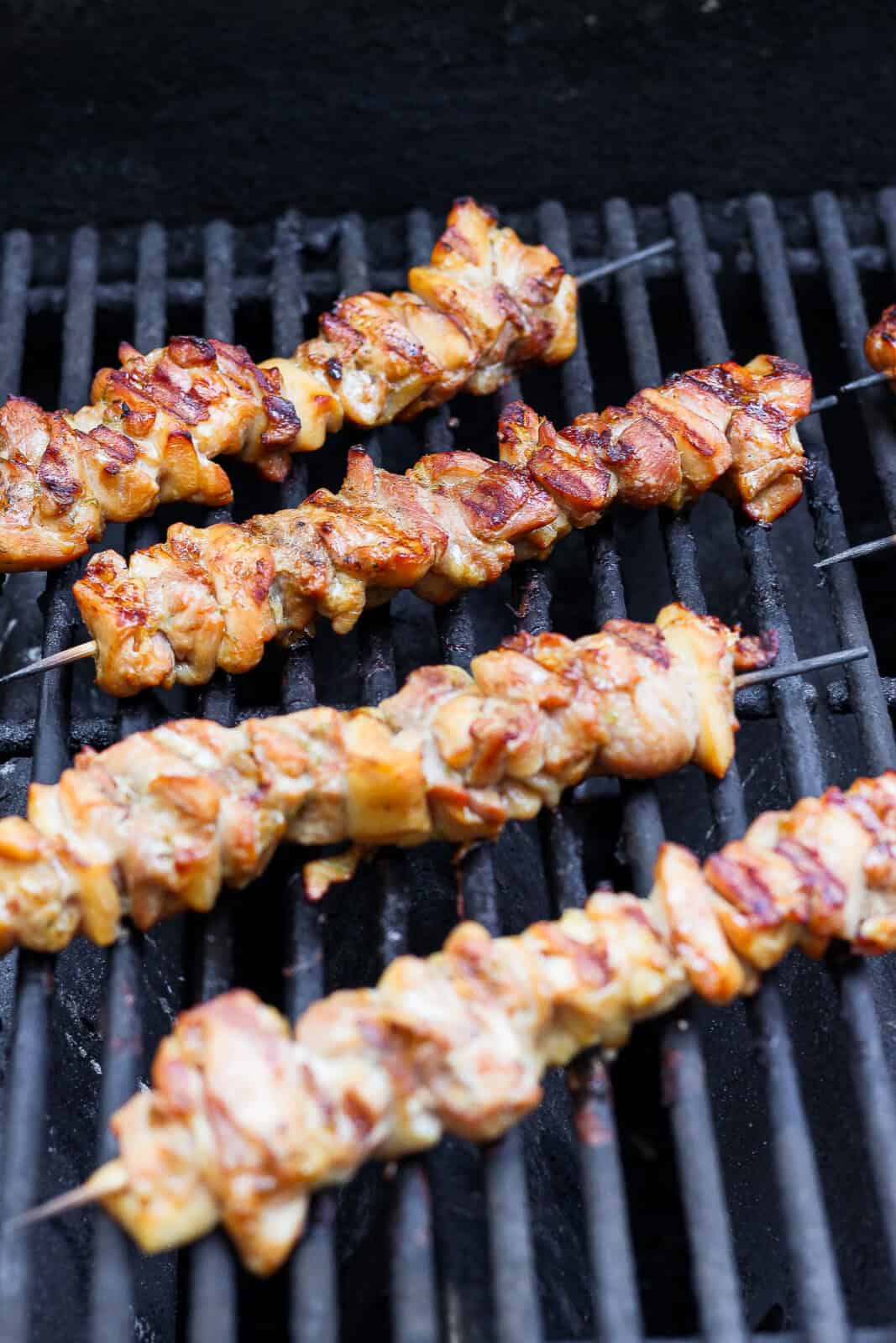 Thai chicken skewers cooking on the grill.