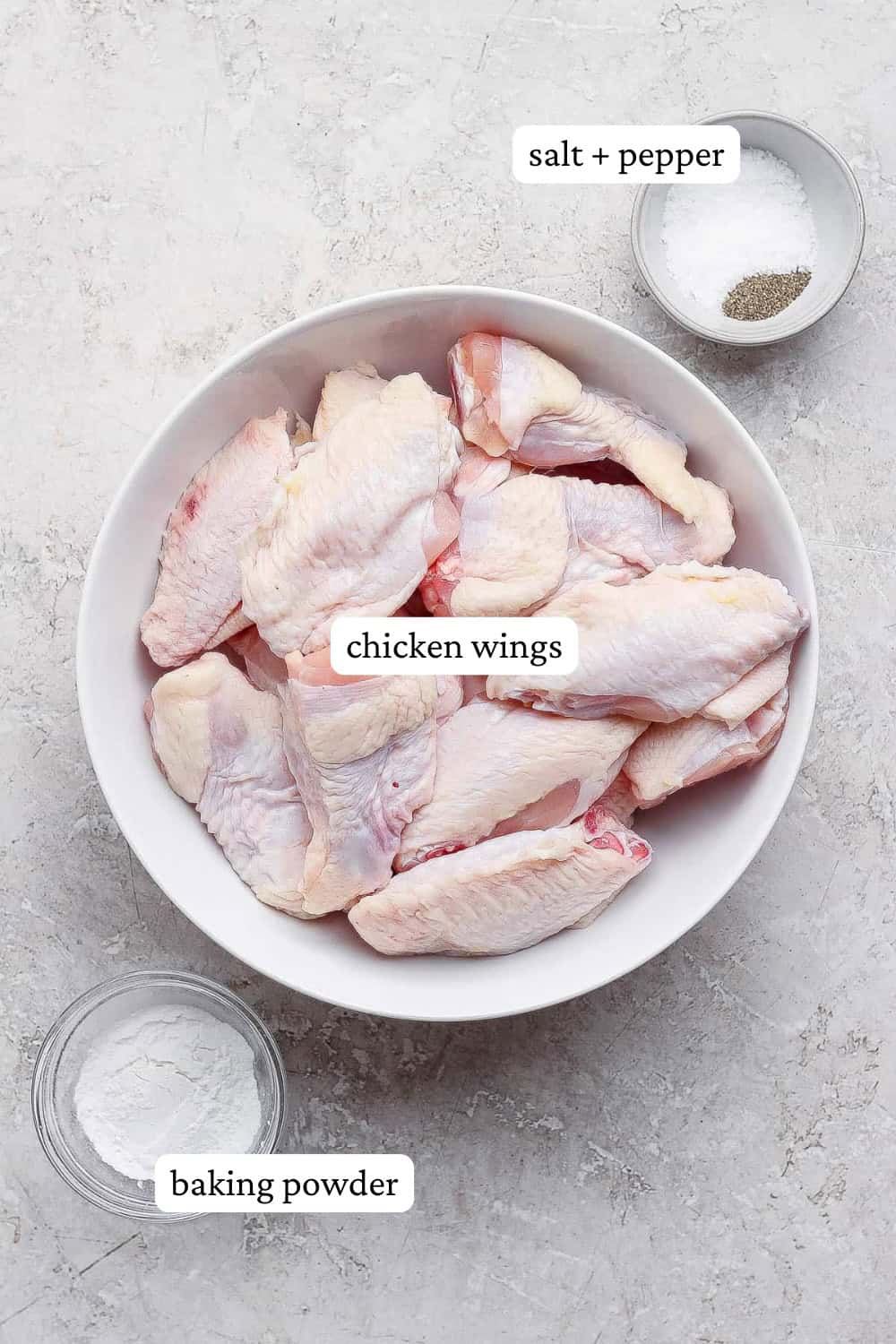 Ingredients for baked chicken wings in separate bowls with labels.