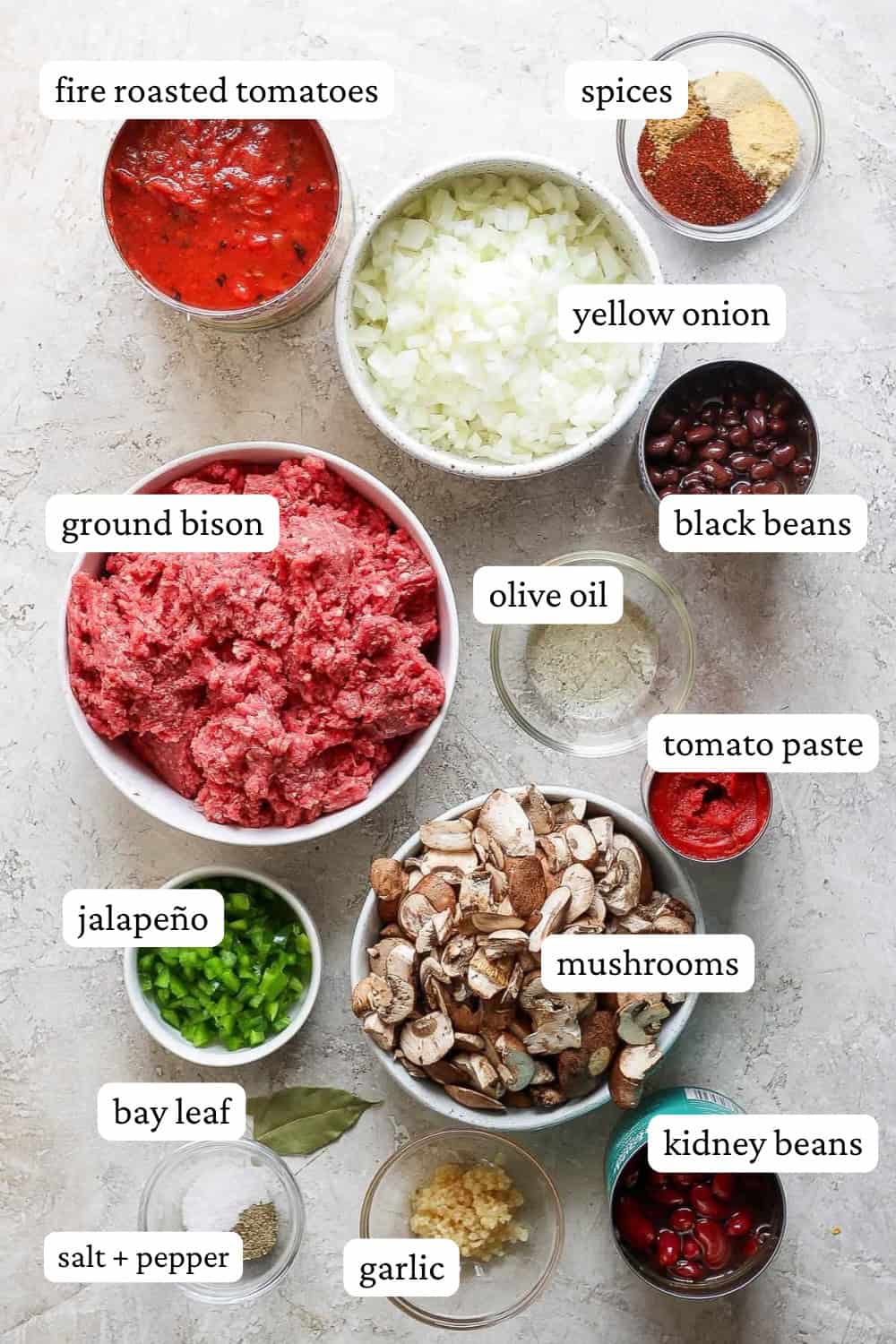 Ingredients for bison chili in separate bowls with labels.