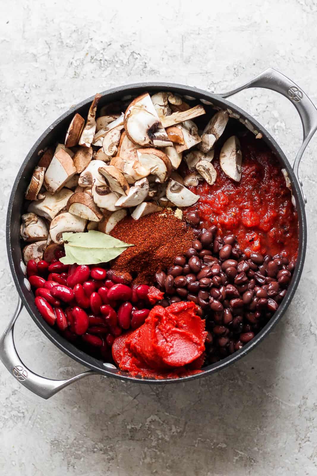 All the ingredients for bison chili in a dutch oven before being mixed or simmering.