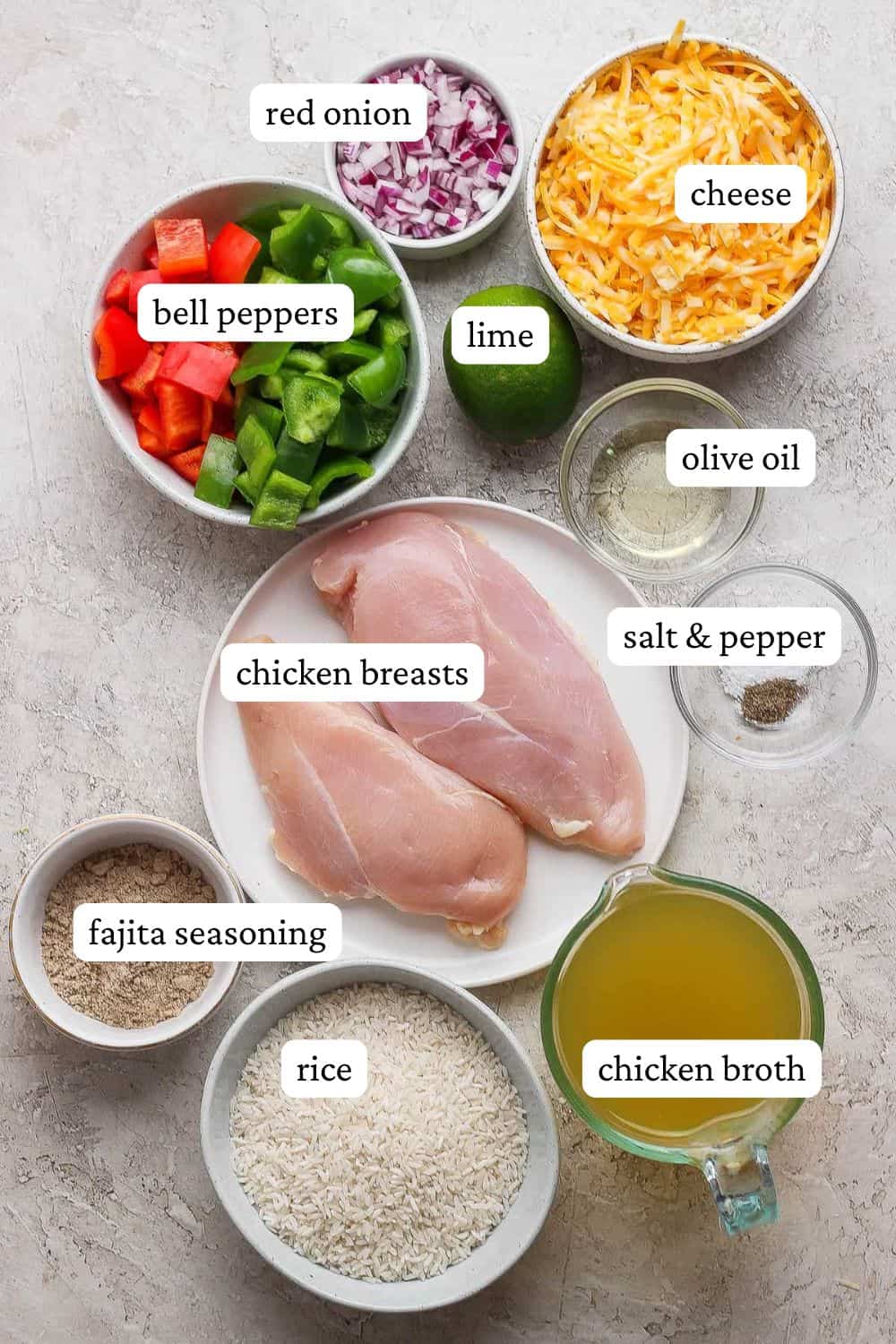 Chicken fajita casserole with rice ingredients including bell pepper, lime, shredded cheese, olive oil, chicken breasts, rice, broth, kosher salt, black pepper, fajita seasoning, and red onion.