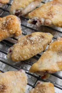 Baked chicken wings resting on a wire rack.