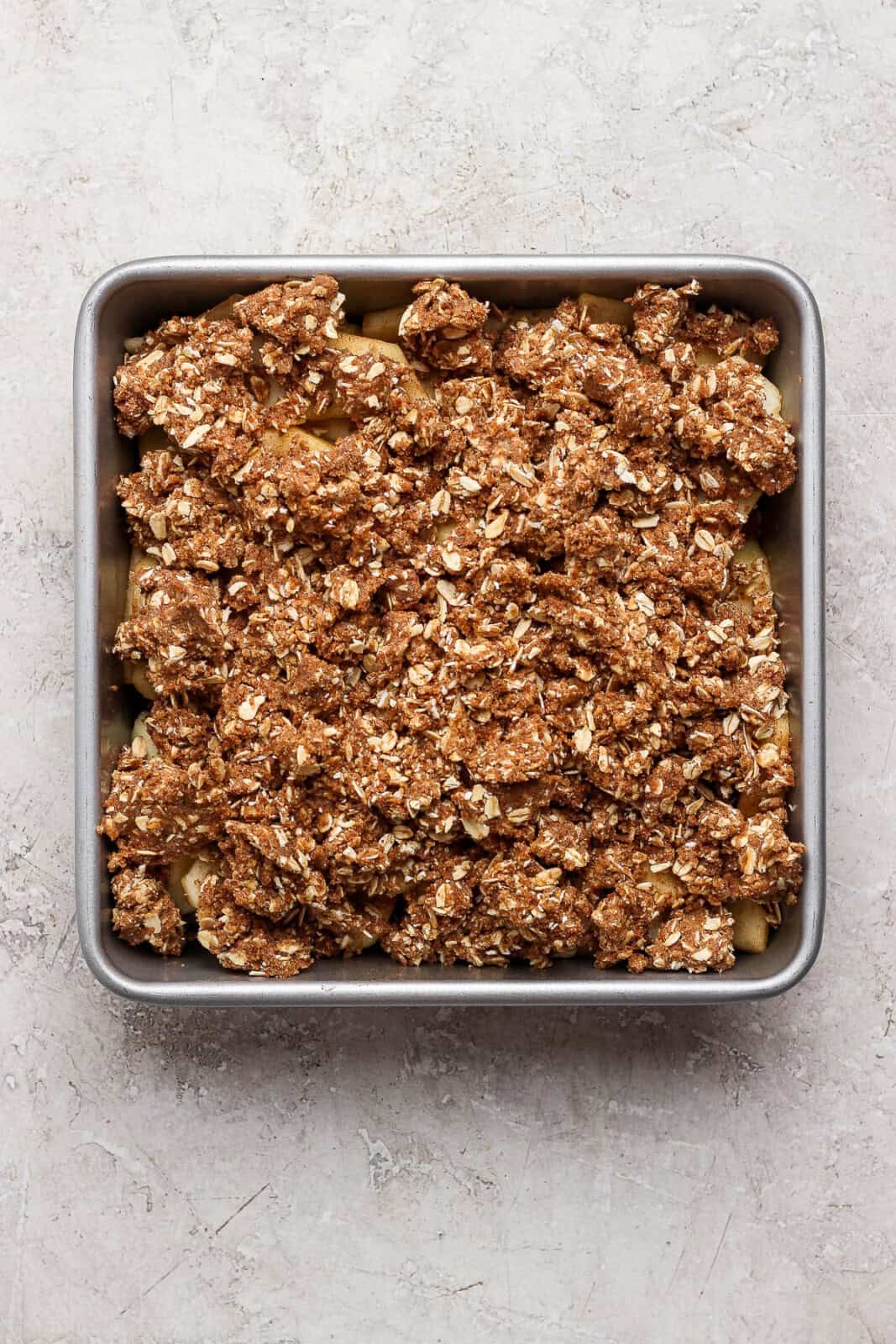 Healthy apple crisp in a baking pan before baking.