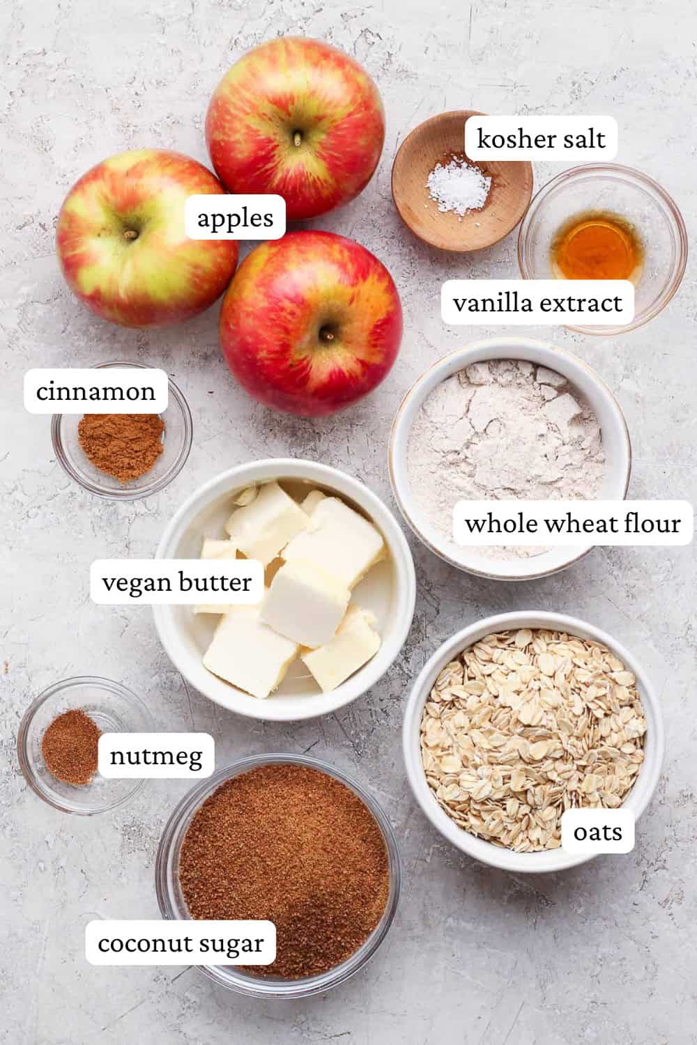 Healthy apple crisp ingredients in separate bowls with labels.