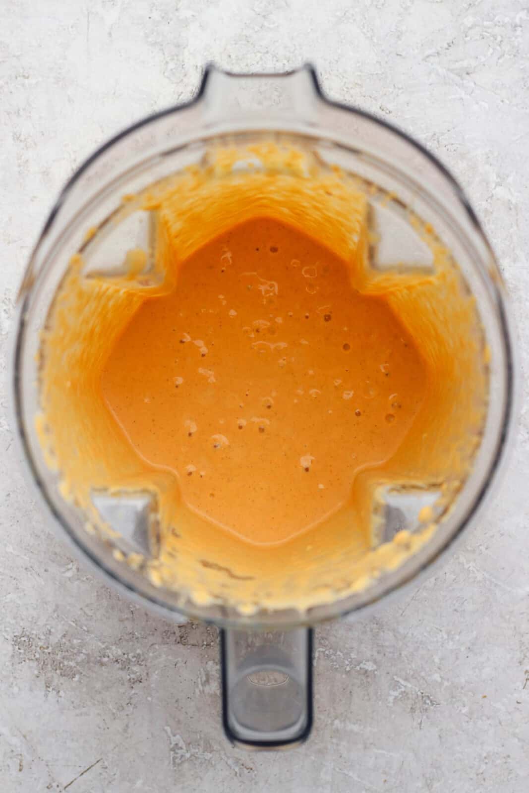 Ingredients for a pumpkin pie shake in a blender after blending.