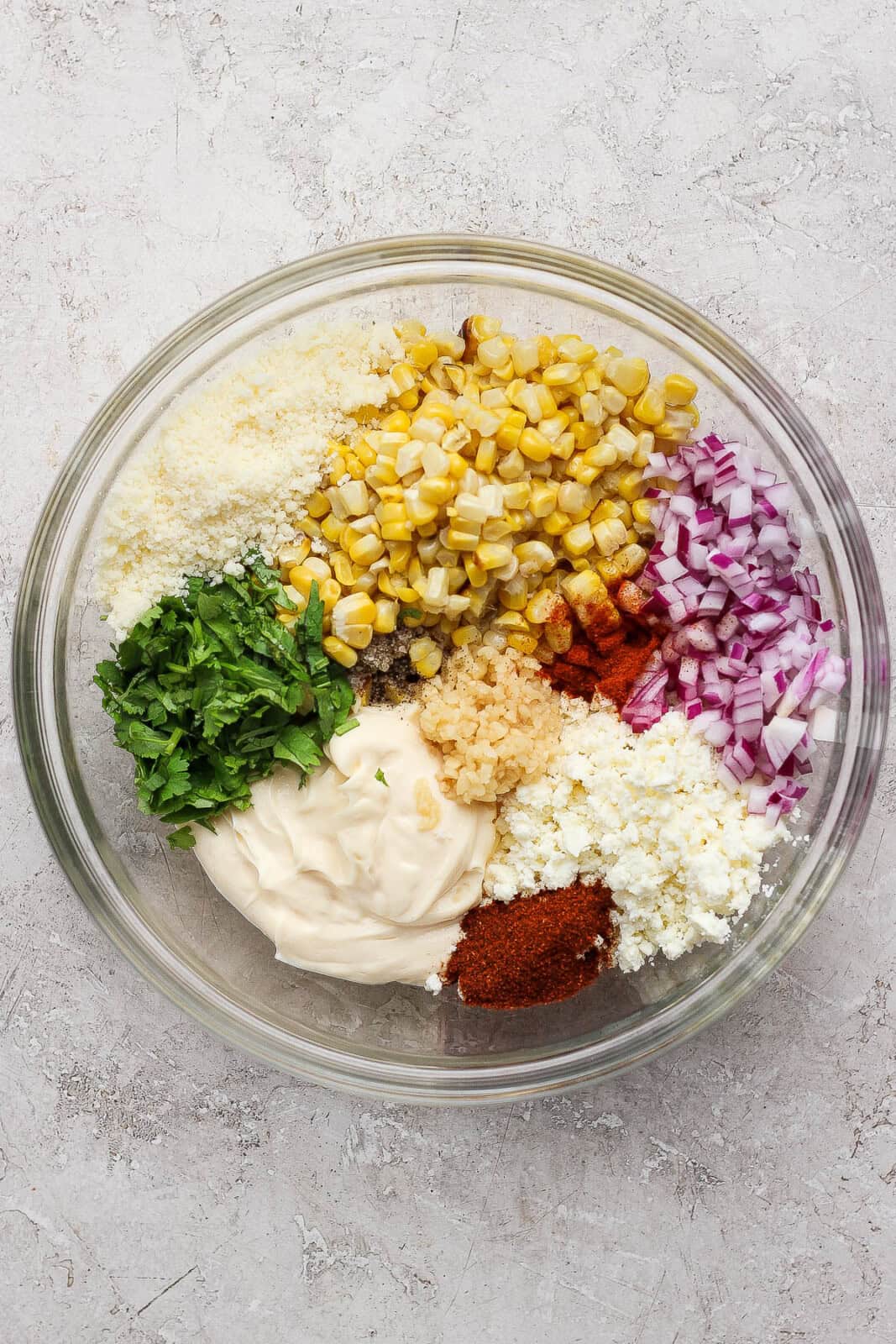 All ingredients for street corn chicken salad (except chicken) separated in a large glass bowl.