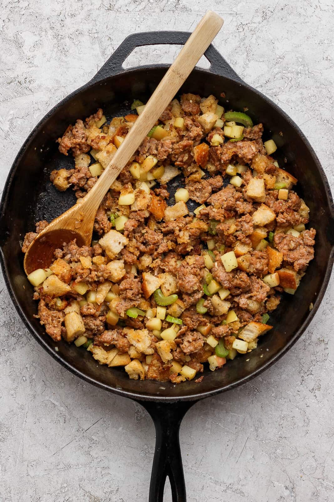 The fully combined stuffing mixture in a skillet for sausage and apple stuffed acorn squash.