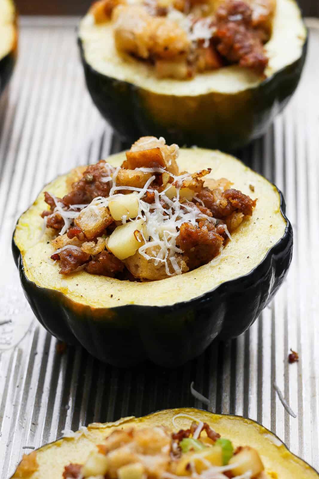 A sausage and apple stuffed squash on a sheet pan after baking.