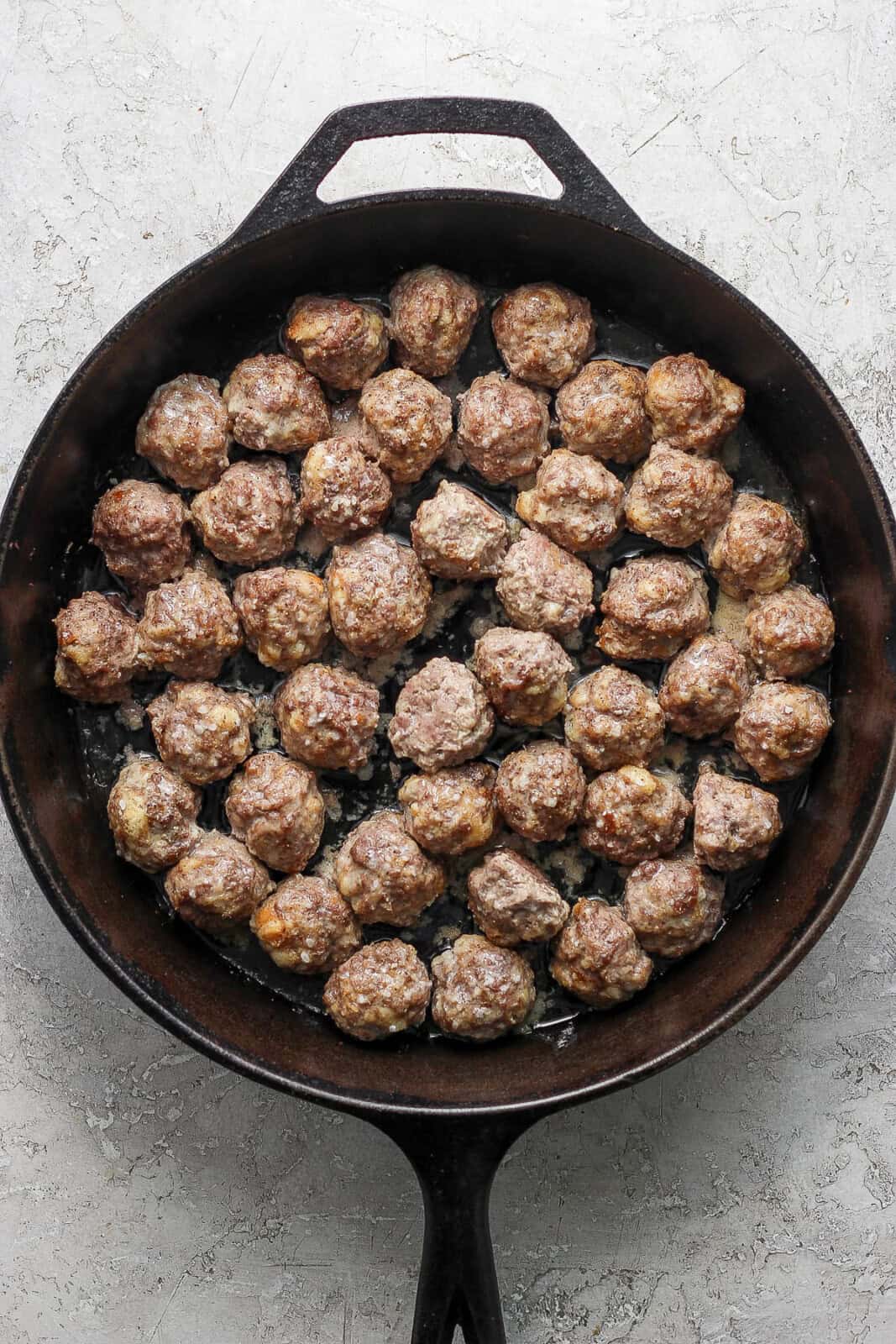 Meatballs for Swedish meatballs in a cast iron skillet after baking.