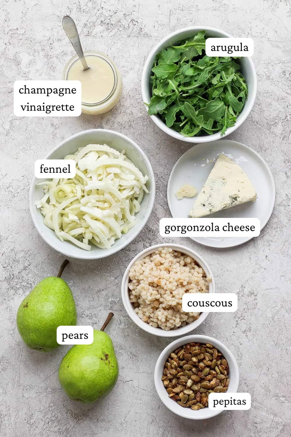 Ingredients for a fennel pear salad in separate bowls with labels.