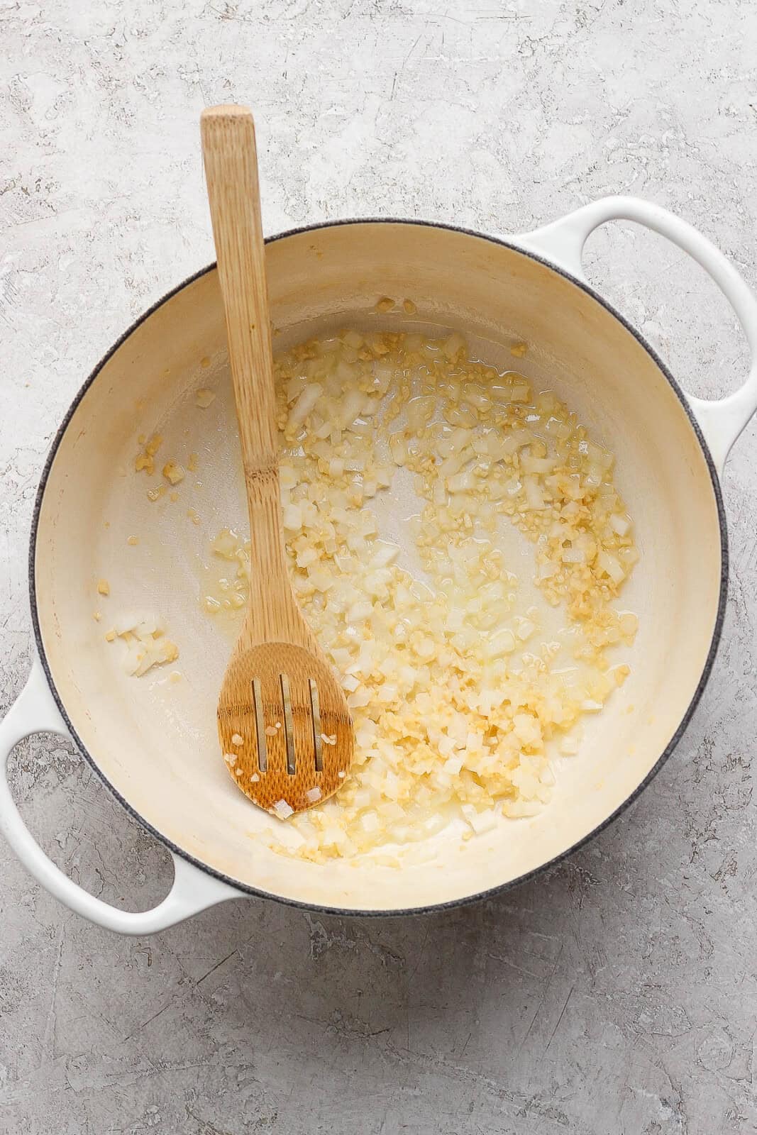 Diced onion and garlic sautéing in a pot for marry me chicken gnocchi soup.