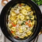 Slow cooker chicken tortellini soup in a slow cooker.