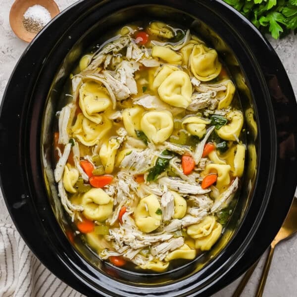 Slow cooker chicken tortellini soup in a slow cooker.