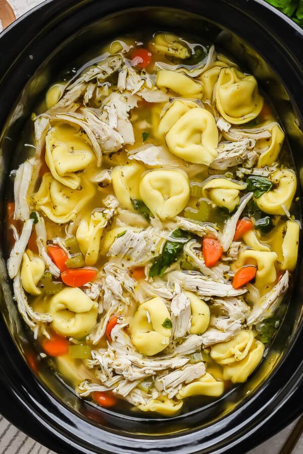 Slow cooker chicken tortellini soup in a slow cooker.
