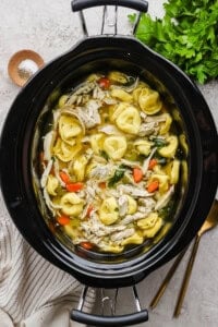Slow cooker chicken tortellini soup in a slow cooker.