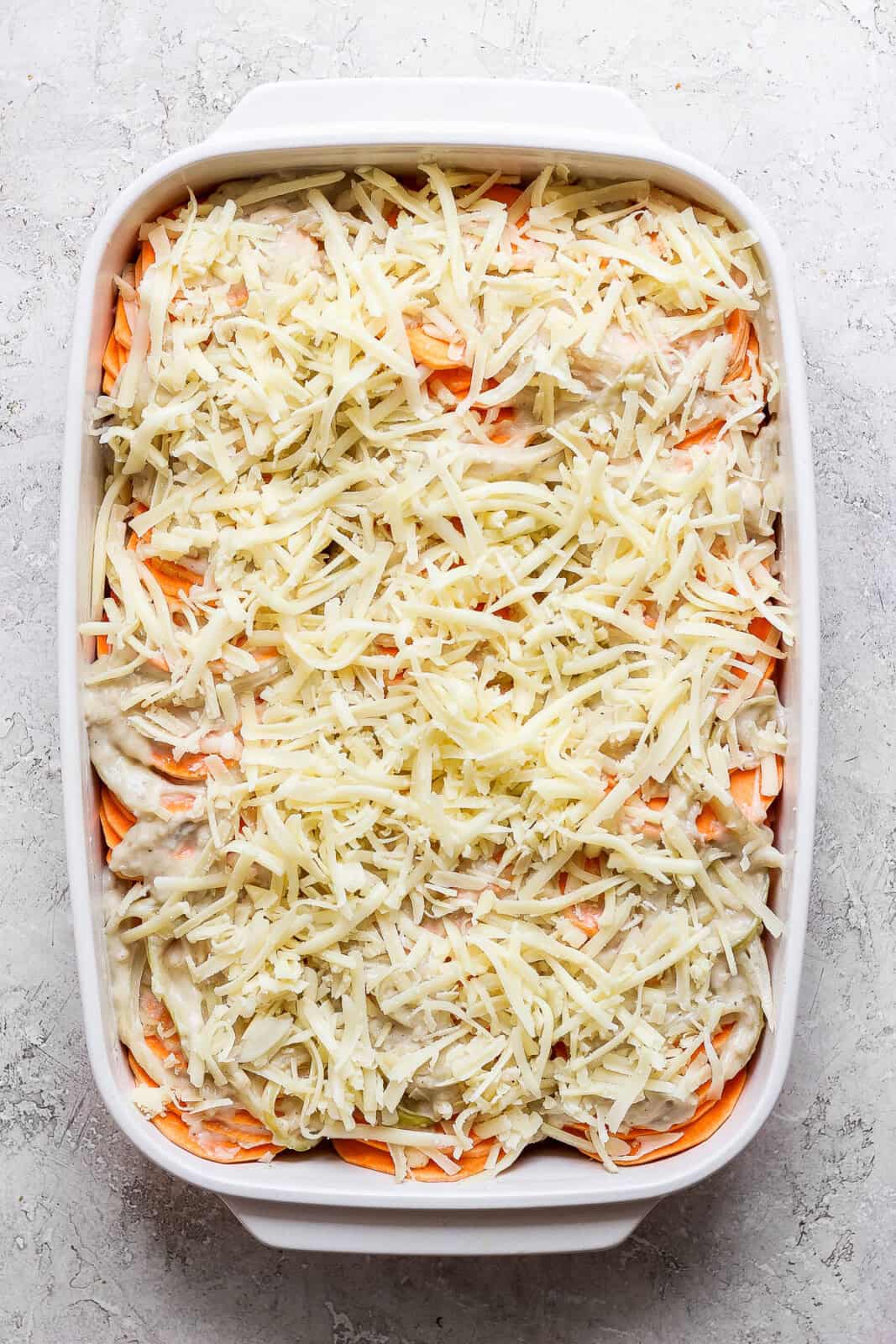 Sweet potato au gratin with the added cheese on top before baking.